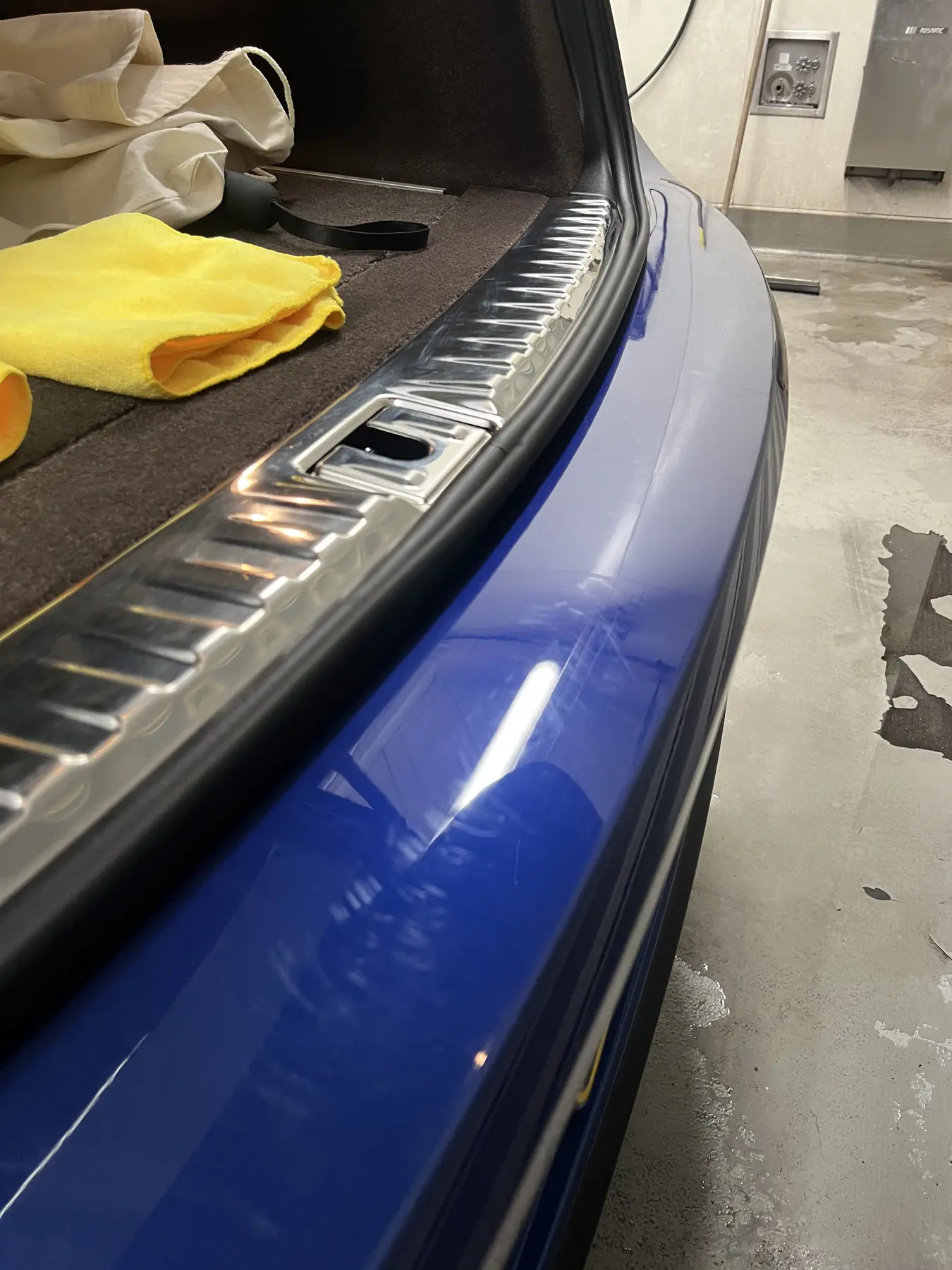 Blue painted bumper with scratches before correction