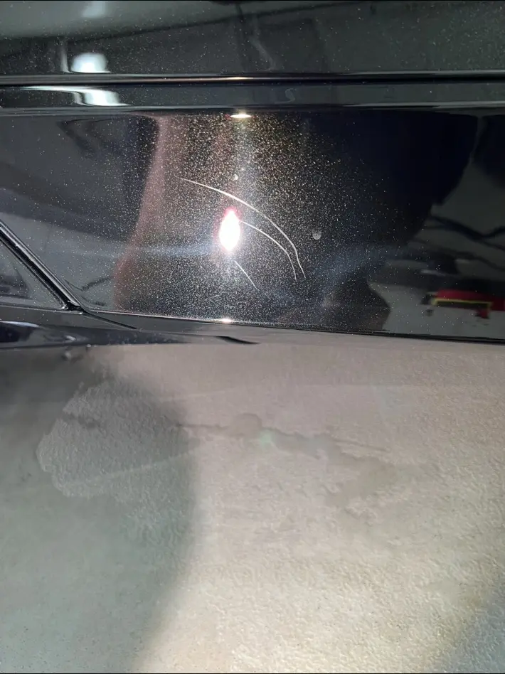 Black painted panel with scratches before correction